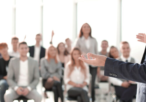 close-up-speaker-standing-front-audience-conference-room-1.jpg